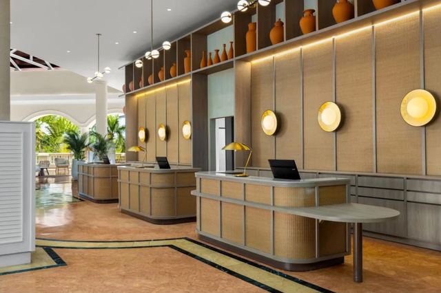 Resort reception desk with warm wood panelling and globe lights