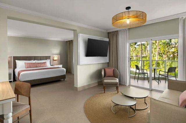Suite with king bed, sitting area and sliding doors to a terrace