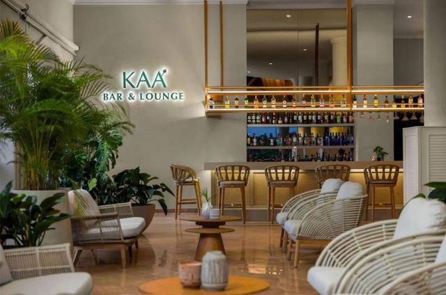 Kaá Bar & Lounge with rattan chairs, plants and a backlit bar